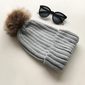 Winter grey knit beanie featuring a large brown faux fur pom pom on white background - Light Gray