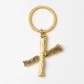 Macro shot of gold alphabet X keychain featuring detailed tree bark texture on metal - Letter X