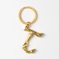 Close-up of golden letter T keychain with realistic bamboo texture and polished metal ring - Letter J