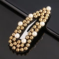 Detailed close-up of a black fabric hair clip with golden beads and white faux pearls - White & Gold Beads