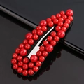 Detail shot of a black snap hair clip covered with glossy red beads and pearls - All Red Beads