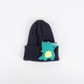Nahaufnahme einer dunkelblauen Rippstrickmütze für Kinder mit grünem Dino-Plüsch-Aufnäher - Marineblau