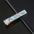 Detail of blue marble acrylic hair clip with golden metal teeth on a reflective surface - Sky Blue Marble