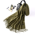 Detail of olive green cashmere scarf with fringe drapes over a black handbag on white background - Army Green