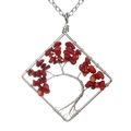 Macro view of a handmade silver wire wrapped square Tree of Life pendant with red stones - Red Coral