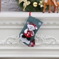 Dettaglio calza di Natale con orsetto 3D su sfondo di camino bianco festivo - Stile A Orso Verde Scuro