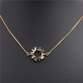 Detailopname van een gouden ketting met een cirkelvormige hanger met gekleurde zirkonia's - Lip