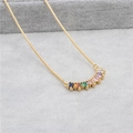 Macro shot of curved pineapple pendant with colorful rectangular zircons on gold chain - Arc