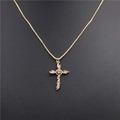 Macro detail of gold cross pendant featuring sparkling cubic zirconia on a box chain - Style B