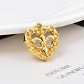 Colgante de corazón dorado con diseño calado de flor de lis sobre blanco - Corazón Fleur-De-Lis (KK34) / Dorado