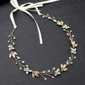 Exquisite bridal leaf hair band with sparkling rhinestones and elegant white ribbon tie - Gold