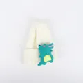 Detailansicht der weißen Kinderstrickmütze mit einem niedlichen grünen Dino-Plüschaufnäher - Weiß