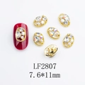 Close-up of golden oval hollow nail charm with teardrop zircon and small pearl detail - Japanese Style Oval Nail Charm (2807) / 10 Pieces Pack