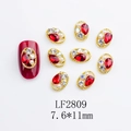 Detailed view of LF2809 nail art alloy charm with red teardrop gem and twisted gold frame - Japanese Style Oval Nail Charm (2809) / 10 Pieces Pack