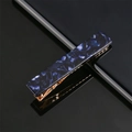 Detailed close-up of blue marble acrylic hair clip with a gold metallic base - Deep Blue Marble