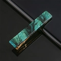 Macro detail of marbled dark green acetate hair clip with gold metal grip and sparkles - Black and Dark Green Marbled