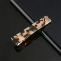 Close-up of a rectangular leopard print acetate hair clip with golden metal base - Beige Leopard