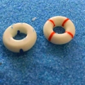 Détail de deux mini bouées de sauvetage sur sable bleu pour micro paysages de mousse - Bouée de Sauvetage Rouge / Diamètre 1.5cm