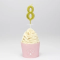 Glittering gold number 8 birthday candle on top of a decorated cream cupcake - Number 8