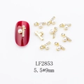 Detailed view of alloy shell nail art charms with pearls and zircons on red nails - Gold Pearl Cross Style (LF2853)