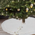Detail of cable knit Christmas tree skirt with white pom-poms and decorative bow tie - White Knitted Tree Skirt 122 / White