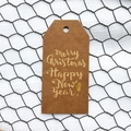 Brown kraft paper Christmas gift tag with gold Merry Christmas lettering on white fabric - Simple Style C