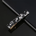 Close-up of a marbled acetate hair clip with black and white patterns on a mirror - Black and White Marble