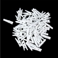 Mucchio di piccole clip in legno bianco con molle metalliche su sfondo nero - Bianco
