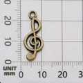 Antique bronze G-clef musical note charm measured on a metric grid scale board - G-Clef-1107