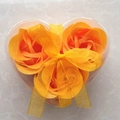 Three orange soap roses in a heart-shaped gift box with a yellow ribbon bow decoration - Orange