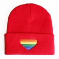 Detailansicht der roten Strickmütze mit regenbogenfarbener Herzstickerei am Umschlagsaum - Regenbogenherz / Rot