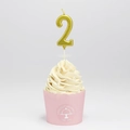 Metallic gold number 2 birthday candle on a cupcake with a gray background - Number 2