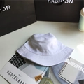 Minimalist white wide brim cotton bucket hat displayed on a modern office desk setup - 5.5cm Brim/No Windproof Rope / White