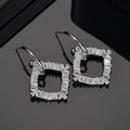 Eleganti orecchini quadrati in argento con zirconi baguette su superficie riflettente - Argento (Placcato Oro Bianco)
