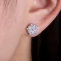 Macro view of crystal flower stud earrings with marquise cubic zirconia on earlobe - White