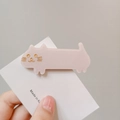 Pink glitter cat hair clip made of acetate resin with gold facial details held in hand - Glitter