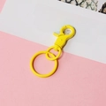 Detail of yellow metal lobster clasp with key ring featuring colorful lacquer finish - Yellow