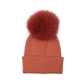 Soft orange knit beanie hat featuring a large burgundy fluffy fur pompom on top. - Caramel color