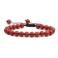 Detail of red stone beaded bracelet with adjustable black braided cord on white background - Red Jasper