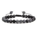 Macro view of beaded bracelet with black and spotted stones on adjustable woven cord - Snowflake Obsidian