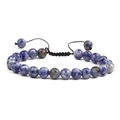 Vue macro d'un bracelet en perles de pierre bleue naturelle avec cordon tressé ajustable - Sodalite