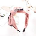 Detail of pink fabric headband with a large contrasting bow and cotton branch decor - Pink