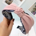 Pink fabric knot headband with contrast paisley lining shown in a high-quality close-up - Pink