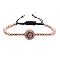Pulsera tejida de oro rosa con amuleto ojo turco de circón azul en fondo blanco - Oro rosa