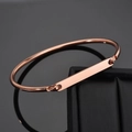 Macro shot of rose gold plated C-shape cuff bracelet with a polished rectangular metal plate - Rose Gold