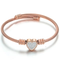 Close-up of rose gold twisted cable bracelet with a sparkling crystal heart charm - Rose Gold