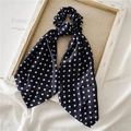 Detailopname van de marineblauwe haarelastiek met stippen en lint op gestructureerde stof - Marineblauwe Polka Dot