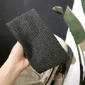Dark grey ribbed knit headband for yoga and makeup, shown in hand for texture detail - Flat Band / Dark Gray