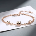 Elegant rose gold double-layer chain bracelet featuring hourglass pendant and polished beads - Layered Style / Rose Gold