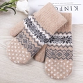 Beige Fair Isle knit mittens with warm snowflake patterns on a rustic wooden background - One Size / Camel